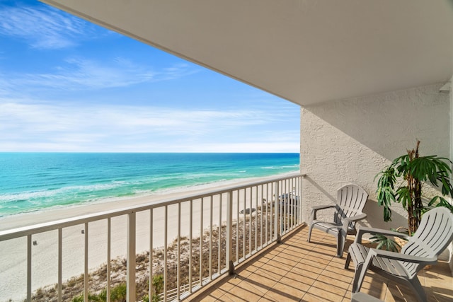 balcony featuring a view of the beach and a water view