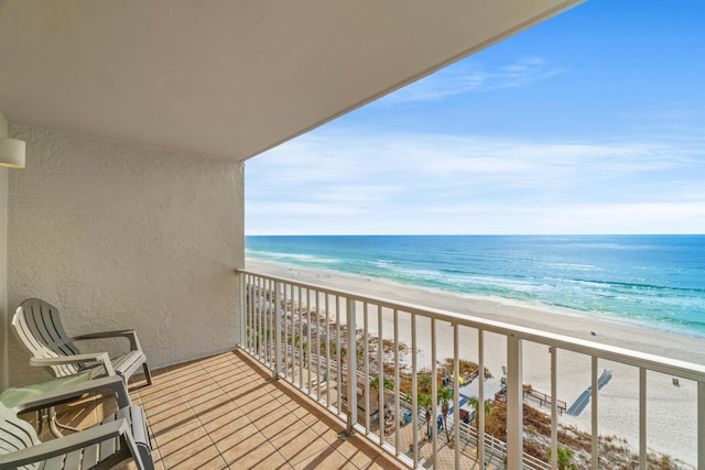 balcony with a water view and a view of the beach