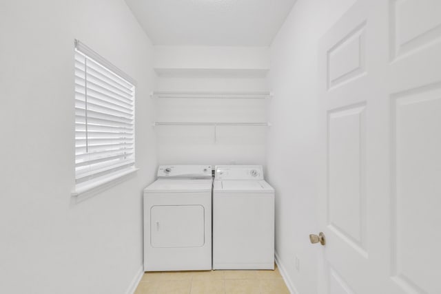 laundry room featuring laundry area, light tile patterned floors, baseboards, and washing machine and clothes dryer