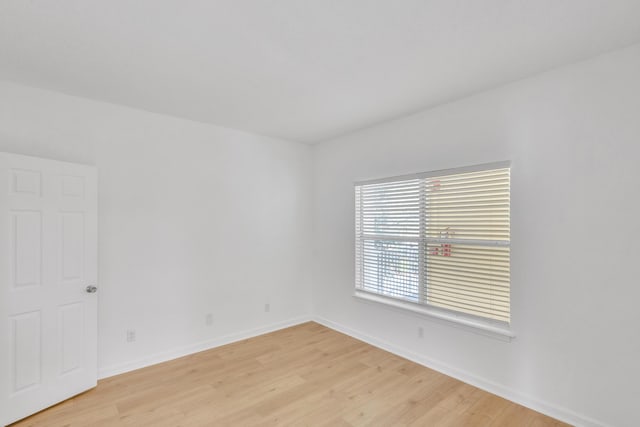 unfurnished room with light wood finished floors and baseboards