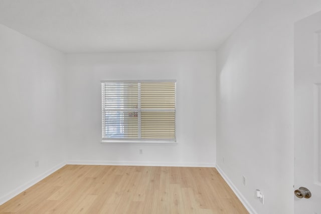 unfurnished room with baseboards and light wood-style flooring