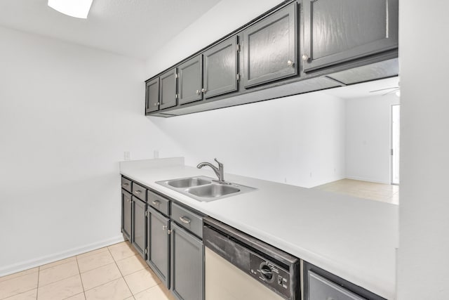 kitchen featuring baseboards, dishwasher, light countertops, light tile patterned floors, and a sink