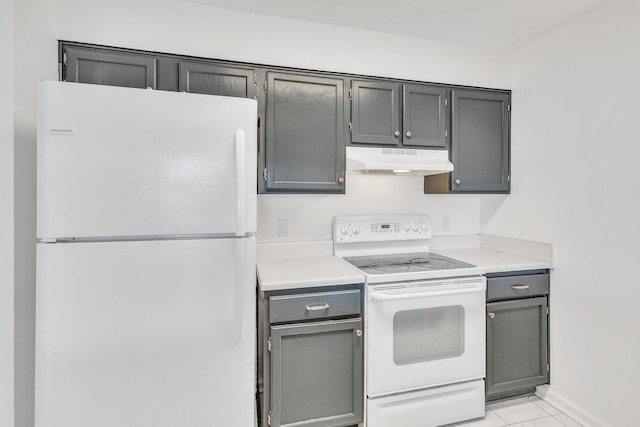 kitchen featuring white appliances, light countertops, baseboards, and under cabinet range hood