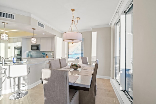 dining space featuring visible vents, crown molding, and baseboards