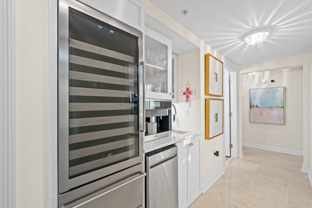 kitchen with baseboards, wine cooler, light countertops, white cabinetry, and a warming drawer