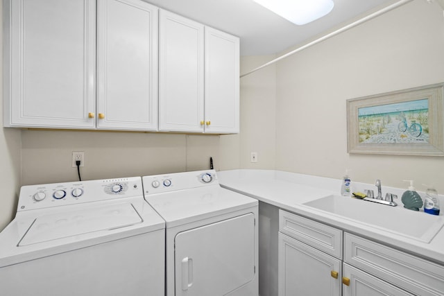 laundry room with washer and dryer, cabinet space, and a sink