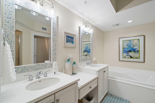 bathroom with a garden tub, visible vents, and a sink