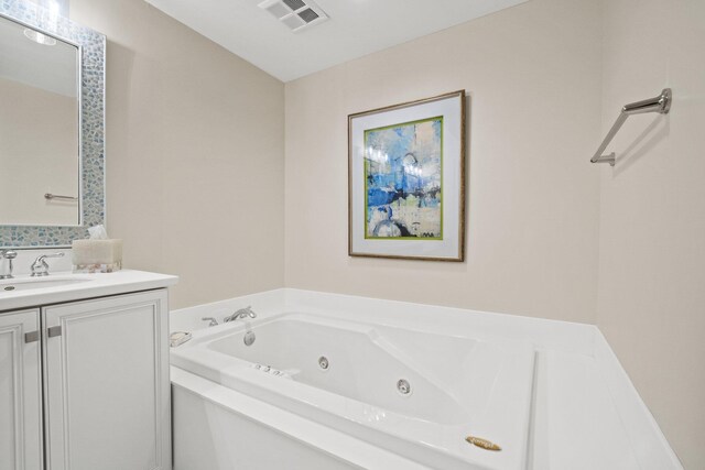 bathroom featuring visible vents, a whirlpool tub, and vanity