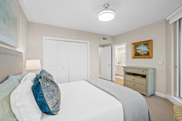 bedroom featuring visible vents, baseboards, light carpet, ensuite bathroom, and a closet