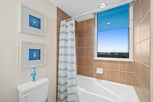 bathroom featuring shower / bath combo with shower curtain and toilet