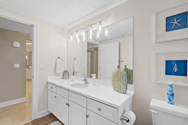 bathroom with tile patterned flooring, toilet, vanity, and baseboards