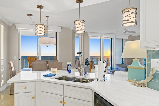 kitchen featuring pendant lighting, white cabinetry, and a sink