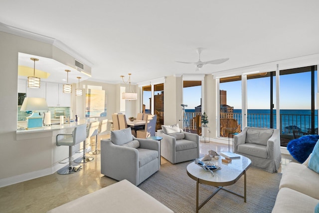 living room with crown molding, baseboards, visible vents, and a water view