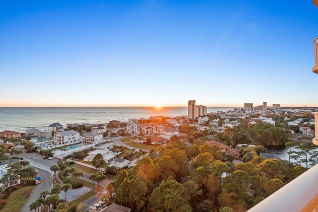 aerial view at dusk featuring a water view