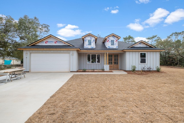 view of front of home with a garage, french doors, board and batten siding, and driveway