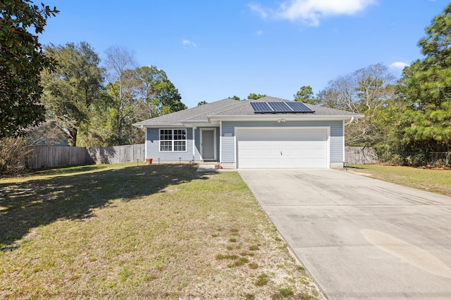 single story home featuring solar panels, fence, concrete driveway, a front yard, and a garage