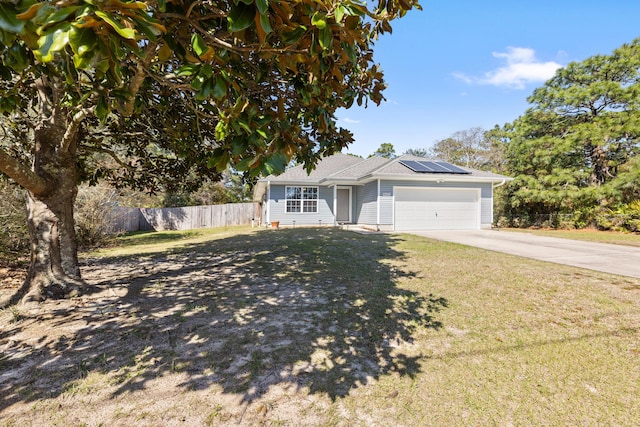 ranch-style house featuring solar panels, a front lawn, fence, concrete driveway, and a garage