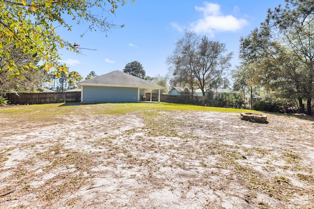 view of yard featuring a fire pit and a fenced backyard