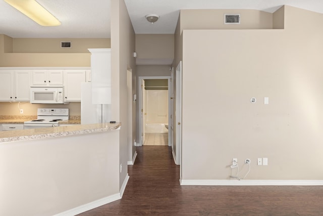 kitchen featuring visible vents, white appliances, dark wood-style flooring, and white cabinetry