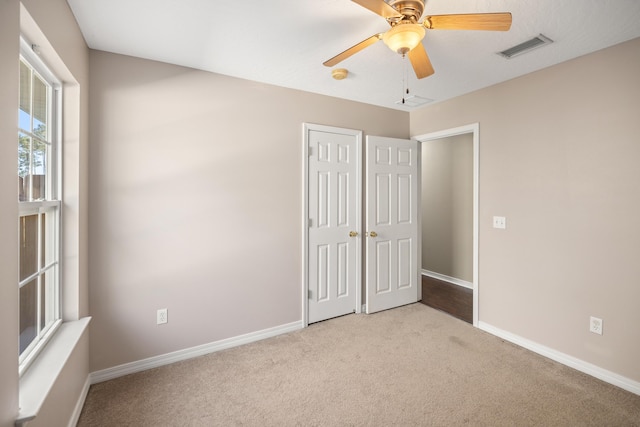 unfurnished bedroom with a closet, visible vents, carpet flooring, and baseboards