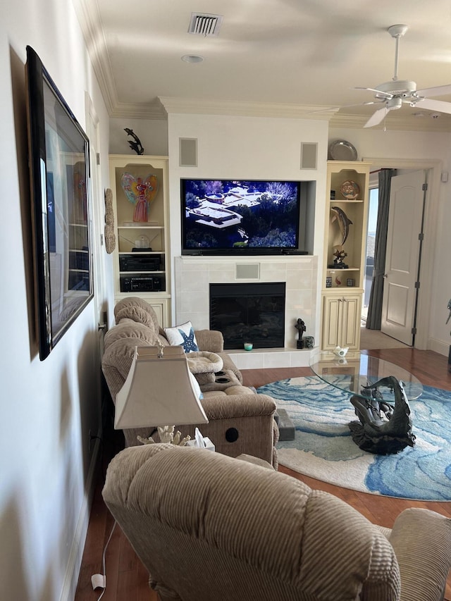 living room featuring visible vents, ornamental molding, and a fireplace