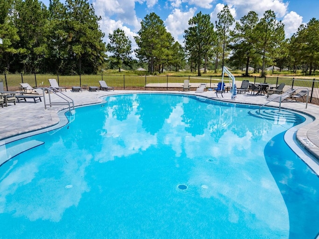 pool with a patio and fence