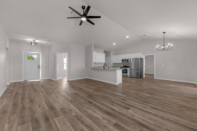 unfurnished living room featuring a sink, ceiling fan with notable chandelier, baseboards, and wood finished floors