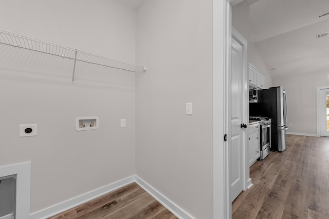 clothes washing area with baseboards, washer hookup, laundry area, wood finished floors, and hookup for an electric dryer