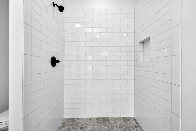 bathroom with tiled shower and toilet