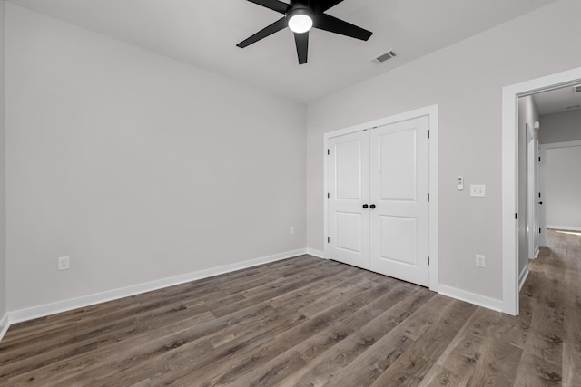 unfurnished bedroom with visible vents, a ceiling fan, wood finished floors, a closet, and baseboards