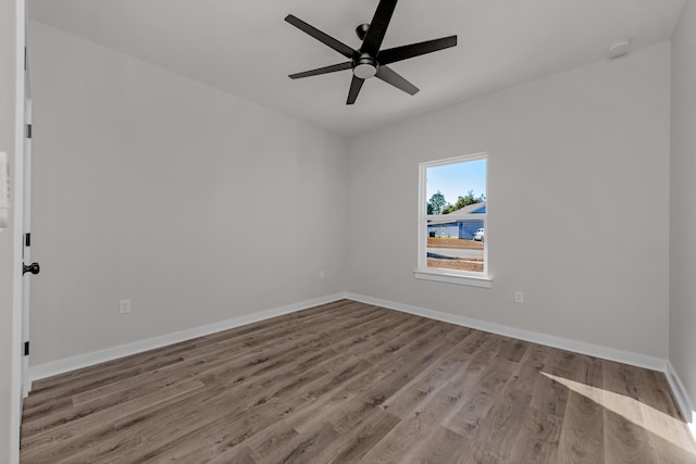 unfurnished room featuring wood finished floors, baseboards, and ceiling fan