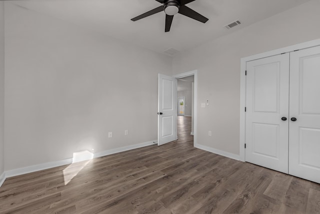 unfurnished bedroom with visible vents, baseboards, a closet, and wood finished floors