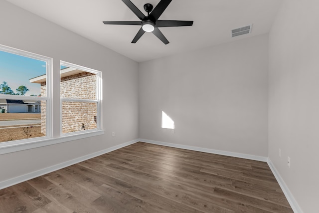 unfurnished room with ceiling fan, visible vents, baseboards, and wood finished floors