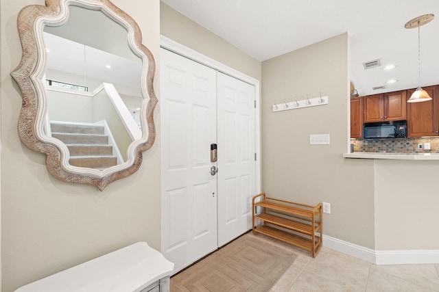 foyer featuring light tile patterned floors, visible vents, baseboards, and recessed lighting