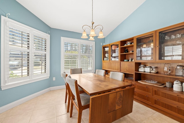 dining area featuring lofted ceiling, light tile patterned floors, baseboards, and a chandelier