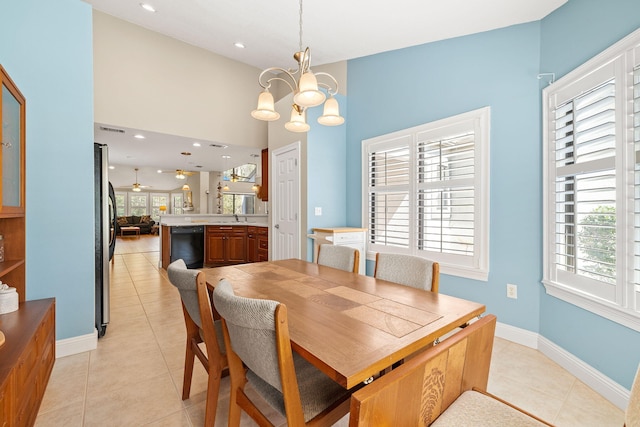 dining space with baseboards, a chandelier, light tile patterned floors, recessed lighting, and a towering ceiling