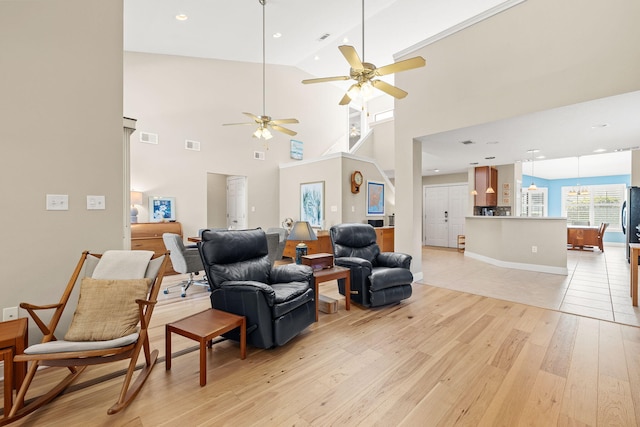 living room with visible vents, light wood finished floors, and ceiling fan