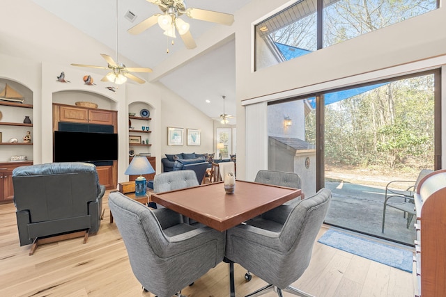 dining room featuring built in shelves, light wood finished floors, and ceiling fan