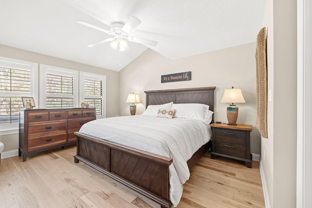 bedroom featuring light wood-type flooring, baseboards, and vaulted ceiling