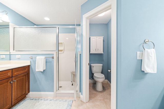 bathroom with vanity, baseboards, tile patterned flooring, a shower stall, and toilet