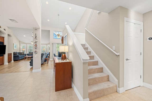 staircase featuring tile patterned flooring, vaulted ceiling, visible vents, and ceiling fan