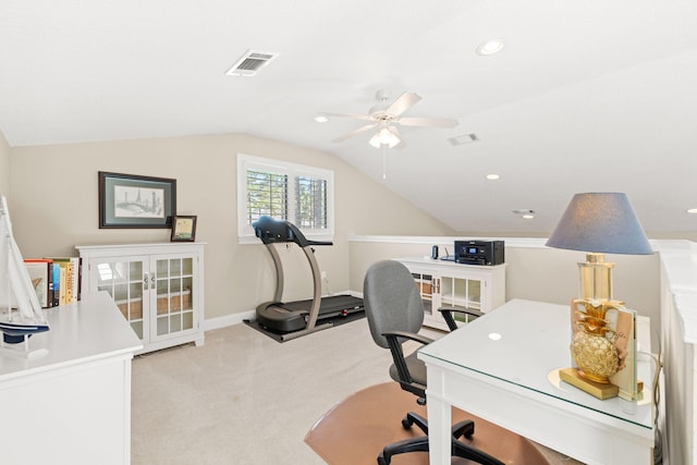 home office featuring a ceiling fan, visible vents, baseboards, vaulted ceiling, and light colored carpet