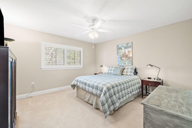 bedroom featuring light colored carpet, baseboards, and ceiling fan