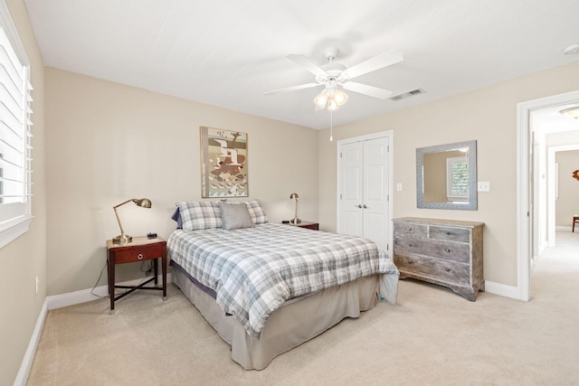 bedroom featuring visible vents, baseboards, light colored carpet, and a closet