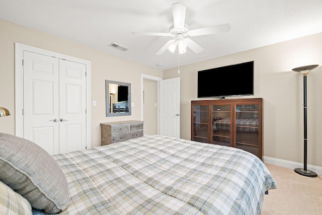 bedroom with visible vents, baseboards, carpet, a closet, and a ceiling fan