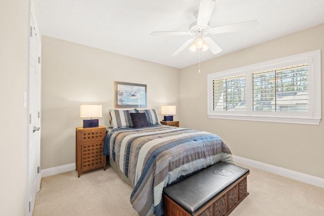 bedroom featuring baseboards, light colored carpet, and ceiling fan