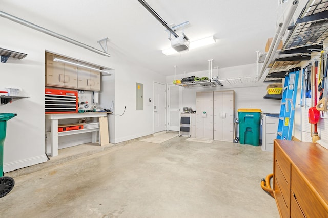 garage featuring electric panel, a workshop area, and a garage door opener