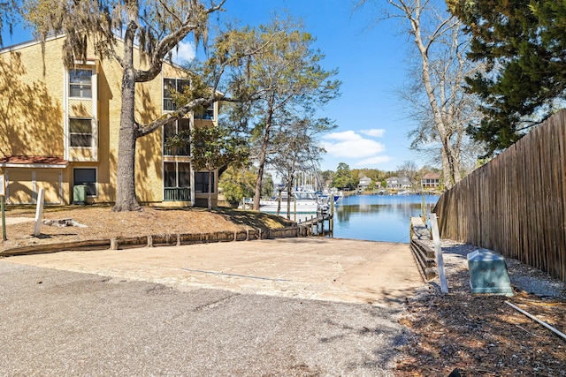 dock area with a water view and fence