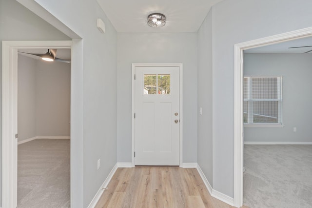 entrance foyer featuring baseboards and light colored carpet