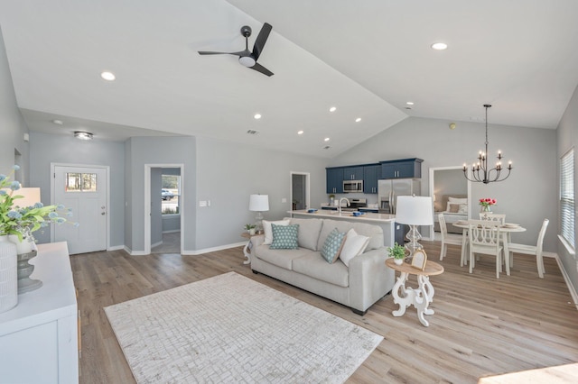 living area featuring baseboards, plenty of natural light, light wood-style floors, and vaulted ceiling